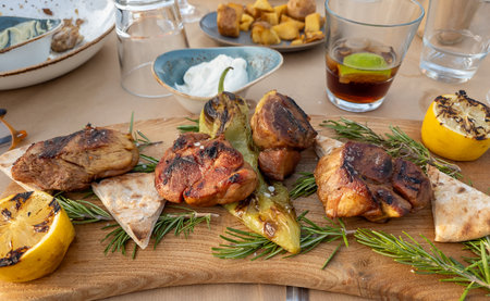 A modern serving of the traditional Greek dish grilled pork with pita and lemon served on a wooden...