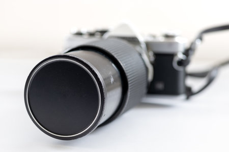 A legacy macro lens attached to a vintage SLR photography camera, isolated in white.の写真素材
