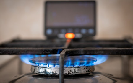 A energy use and cost concept with a smart energy meter close by a gas cooker.の写真素材