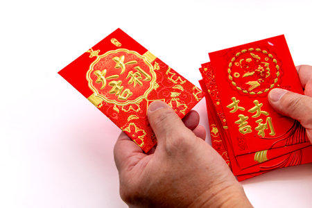 A person handing out Chinese New Year gift of money in red packets with good fortune, luck and...