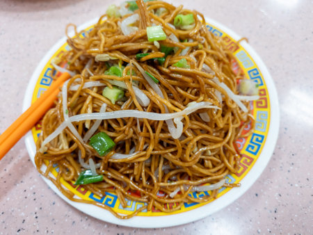 A plate of plain stir fried noodles, chow mein, with bean sprouts and chopped spring onions.の写真素材