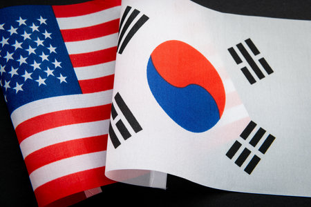 The USA national flag together with the flag of South Korea isolated on black. A USA, South Korea...
