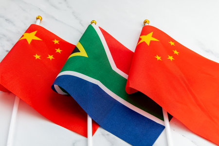 The national flag of South Africa on flag pole in between the Chinese national flag. A South Africa,...