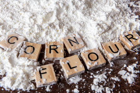 A close up of the words corn flour next to a heap of corn flour.