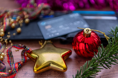 A Christmas on credit concept with a close up of a credit card on an open purse surrounded by Christmas elements.の写真素材