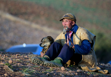 Old man smoking and holding his dog in Kunming, Yunnan, Chinaのeditorial素材