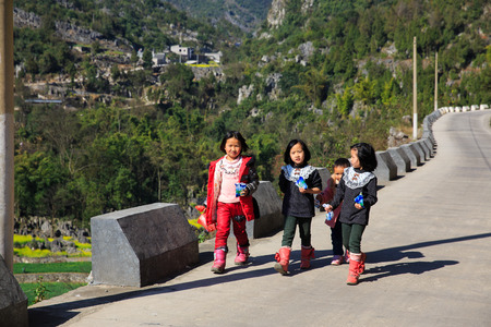 Children walking the road at Guizhouのeditorial素材