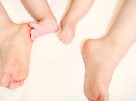 Legs of baby feet and motherの写真素材