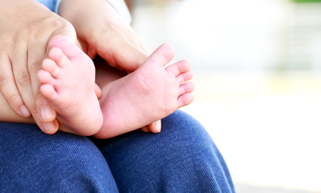 little feet in the mother's handsの写真素材