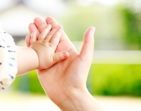 Family scene , closeup parent and baby holding hand togetherの写真素材