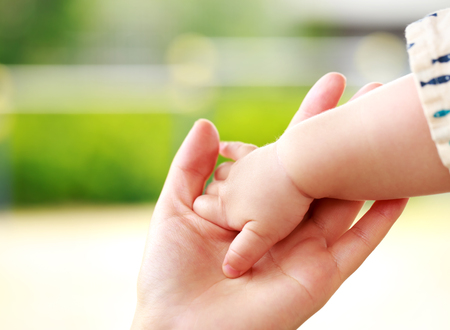 Family scene , closeup parent and baby holding hand togetherの写真素材