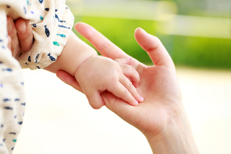 Family scene , closeup parent and baby holding hand togetherの写真素材