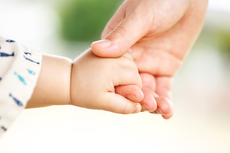Family scene , closeup parent and baby holding hand togetherの写真素材