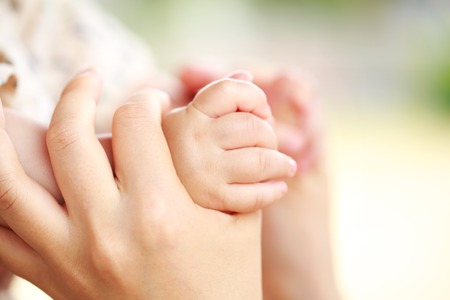 Family scene , closeup parent and baby holding hand togetherの写真素材