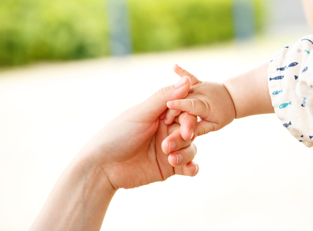 Family scene , closeup parent and baby holding hand togetherの写真素材