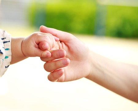Family scene , closeup parent and baby holding hand togetherの写真素材