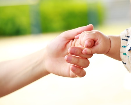 Family scene , closeup parent and baby holding hand togetherの写真素材