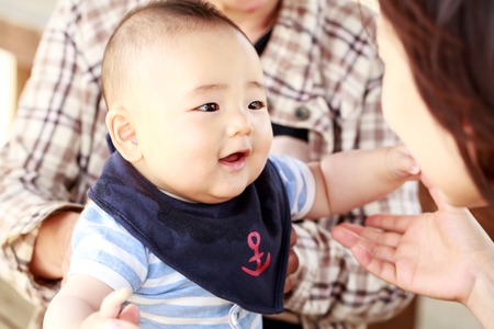 Happy together - smiling baby with his mother and his grandmother outdoorの写真素材