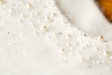 Neck of the Angolan white sweater, pearl and beads. Close upの写真素材