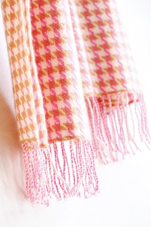 Warm knitted muffler pink hound's-tooth check isolated on white