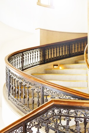 marble spiral staircase with a black and brown fence.It is like the castle.