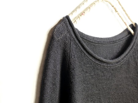 black sweater or cut sew hanging on clothes hanger on white background.close up.