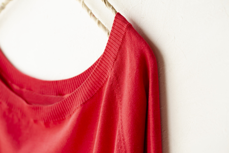 a cut sew or knit in red hanging on clothes hanger on white background.Close up.の写真素材