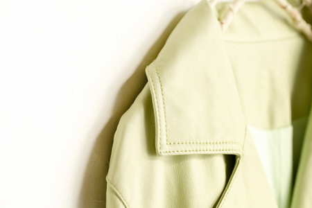 Yellowish green Jacket of the real leather hanging on clothes hanger on white background.close up.