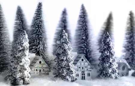 Mini snowy Christmas trees with houses in the forest. Bokeh lights background.close up.の写真素材