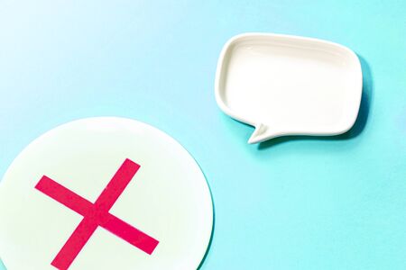 a plate of mark X and white Blank dialog speech bubble of the dish Isolated on sky blue...