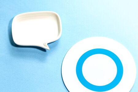a plate of mark O and white Blank dialog speech bubble of the dish Isolated on blue...