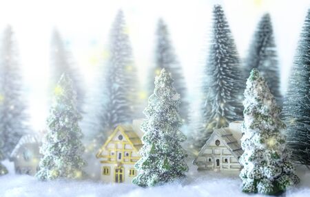 Mini snowy Christmas trees with houses in the forest. Bokeh lights background.close up.の写真素材