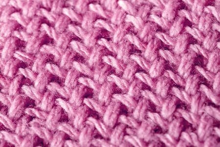 Background texture of pink pattern knitted fabric made of cotton or wool closeupの写真素材