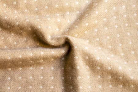 white dots in beige fabric texture and wrinkle useful as a background.close up and copy space.の写真素材