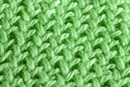 Background texture of green pattern knitted fabric made of cotton or wool closeup
