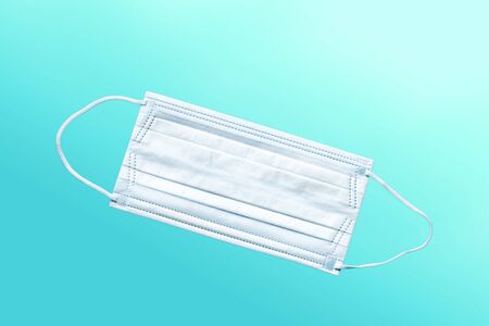 Medical mask, Medical protective mask on blue background. Disposable surgical face mask cover the mouth and nose. Healthcare and medical concept.の写真素材