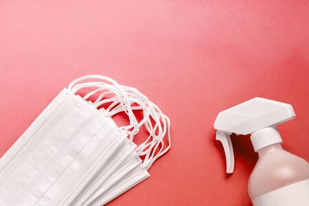 Set of medical masks and Antiseptic solution on red background and copy space.の写真素材