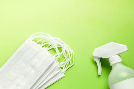 Set of medical masks and Antiseptic solution on yellowish green background and copy space.の写真素材