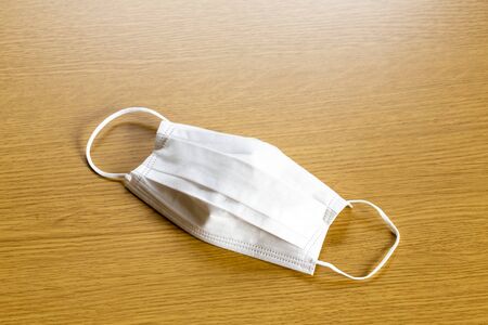 simple white air protection mask on the color surface on blue background. Disposable surgical face mask cover the mouth and nose. Healthcare and medical concept.の写真素材