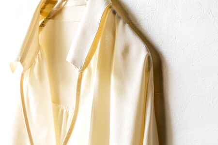a blouse or shirt in white hanging on clothes hanger on white background.Close up and copy space.の写真素材