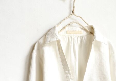 a blouse or shirt in white hanging on clothes hanger on white background.Close up.の写真素材