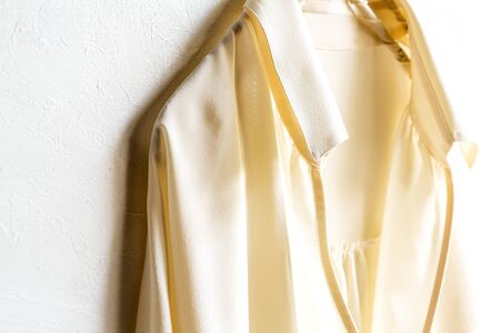 a blouse or shirt in white hanging on clothes hanger on white background.Close up and copy space.の写真素材