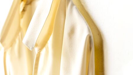 a blouse or shirt in white hanging on clothes hanger on white background.Close up and copy space.の写真素材