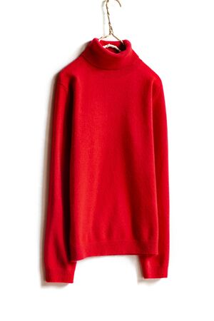 red wool sweater hanging on clothes hanger on white background.close up.の写真素材