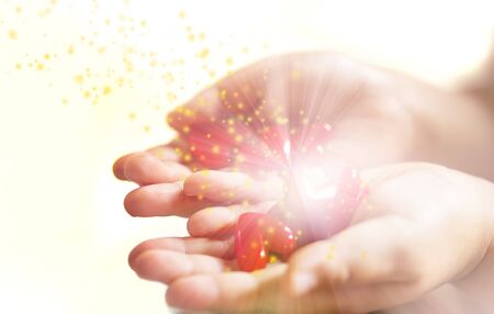 Little child holding red hearts, close up isolated and light, energy with sparkle on white background. health care, love and family concept, world heart day.の写真素材