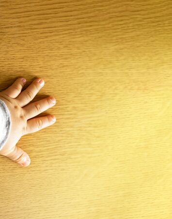 Child's hand showing the five fingers isolated on a wooden background and copy space.の写真素材
