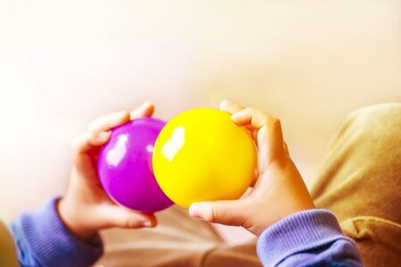 Hands holding purple and yellow two balls and copy space.の写真素材