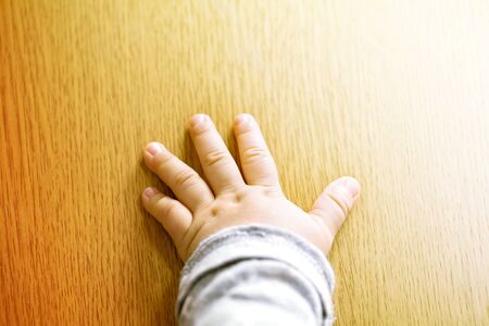 Child's hand showing the five fingers isolated on a wooden background and copy space.の写真素材