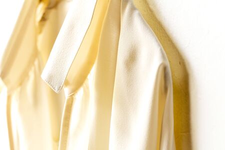 a blouse or shirt in white hanging on clothes hanger on white background.Close up and copy space.の写真素材