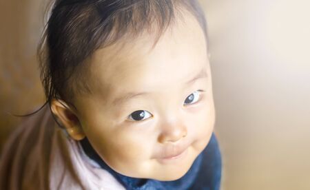 happy pretty baby boy with smile and brown background and copy space.boy looking at the camera.の写真素材